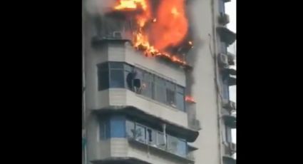 Hombre se cuelga de ventana de edificio para salvarse de incendio (VIDEO) 
