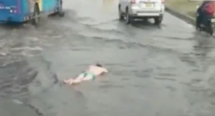 Mujer nada sin ropa en vía pública inundada (VIDEO)