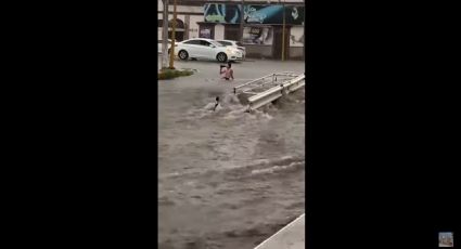 Con caguama en mano hombre enfrenta inundación en Culiacán