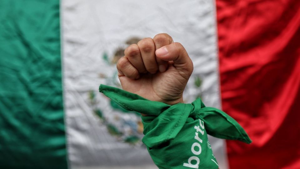 En la imagen una mujer posa con pañuelo verde símbolo del aborto legal