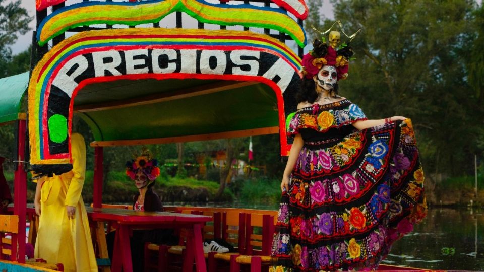 Mujer caracterizada de Catrina en una trajinera de Xochimilco.