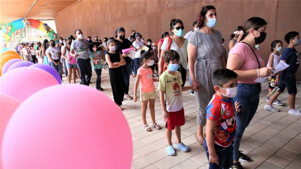 Madres llevando a sus hijos a recibir la vacuna covid.