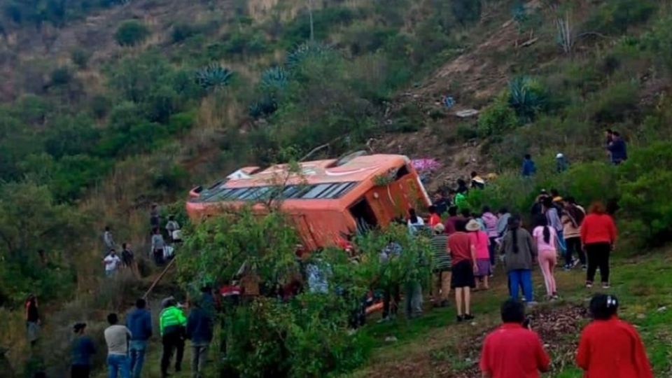 Personas alrededor del autobús que cayó al vacío.