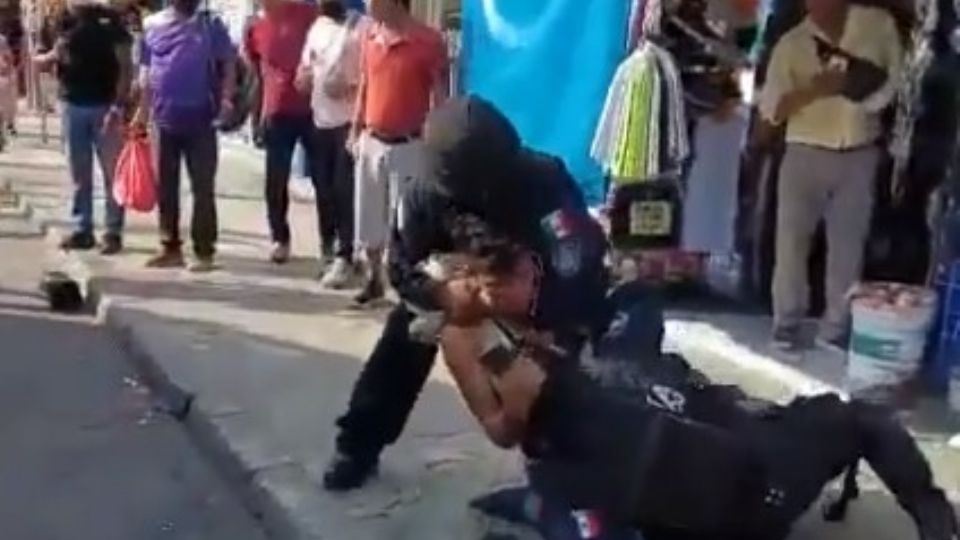 Momento en el que un joven es sometido por elementos de seguridad en Cancún.