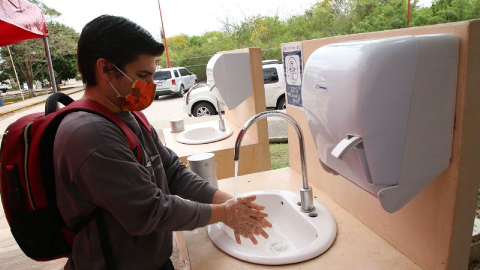 Estudiante se lava las manos como medida de prevención contra COVID-19, tras su regreso a clases presenciales en el país.