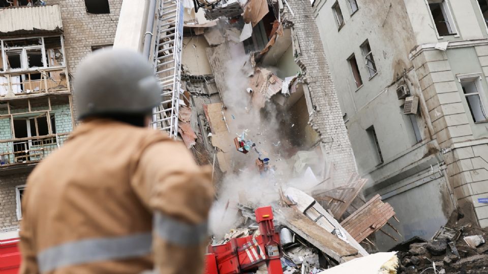 Bomberos retiran los escombros después que un ataque militar alcanzara un edificio, mientras continúa la invasión rusa de Ucrania, en Járkov.