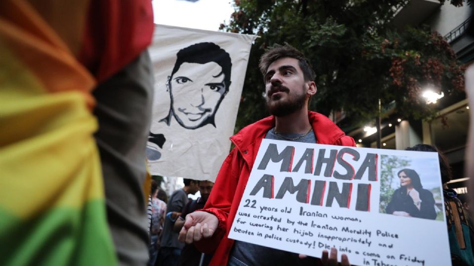 Un hombre muestra un cartel con la imagen de Mahsa Amini.