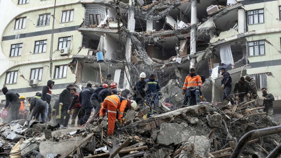 Personal de emergencias buscan supervivientes entre los escombros de un edificio derruido.