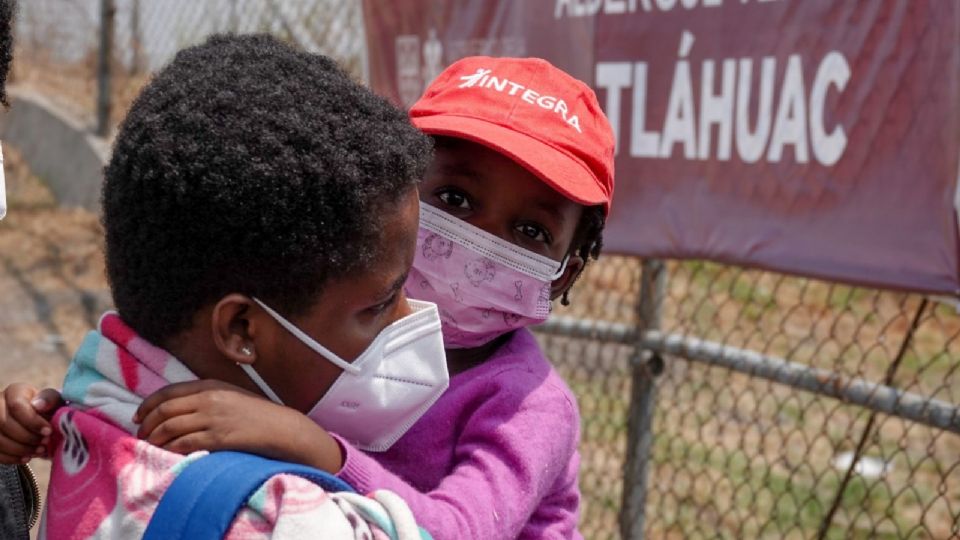 Una madre migrante es fotografiada con su hija.