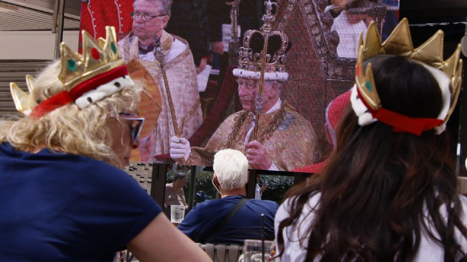 Turistas británicos siguiendo en directo la coronación del rey Carlos III.