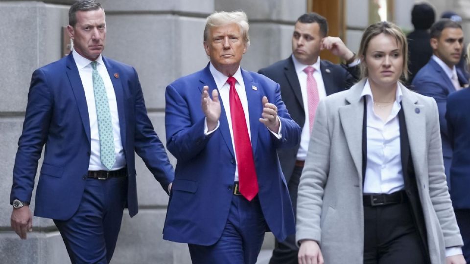 El expresidente estadounidense Donald J. Trump saluda a una multitud al salir de un edificio en el Bajo Manhattan después de asistir al juicio por fraude civil.