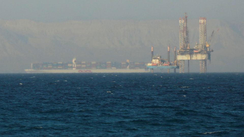 Foto de archivo: un buque portacontenedores cruza una plataforma petrolífera en el Golfo de Suez hacia el Mar Rojo antes de entrar en el Canal de Suez, a las afueras de El Cairo, Egipto 1 de septiembre de 2020.