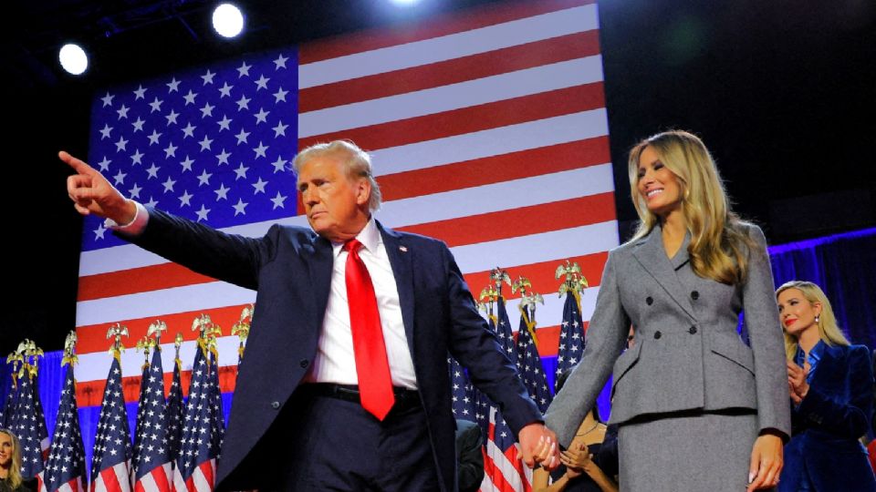 El candidato presidencial republicano y expresidente de Estados Unidos, Donald Trump, realiza un gesto mientras se da la mano con su esposa Melania durante su mitin, en el Centro de Convenciones del Condado de Palm Beach, en West Palm Beach, Florida, Estados Unidos. 6 de noviembre de 2024.