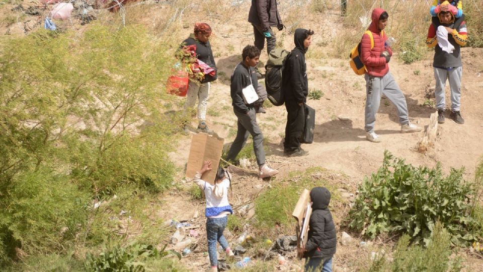 Migrantes que se encuentran varados en la alambrada de la línea fronteriza entre México y Estados Unidos.