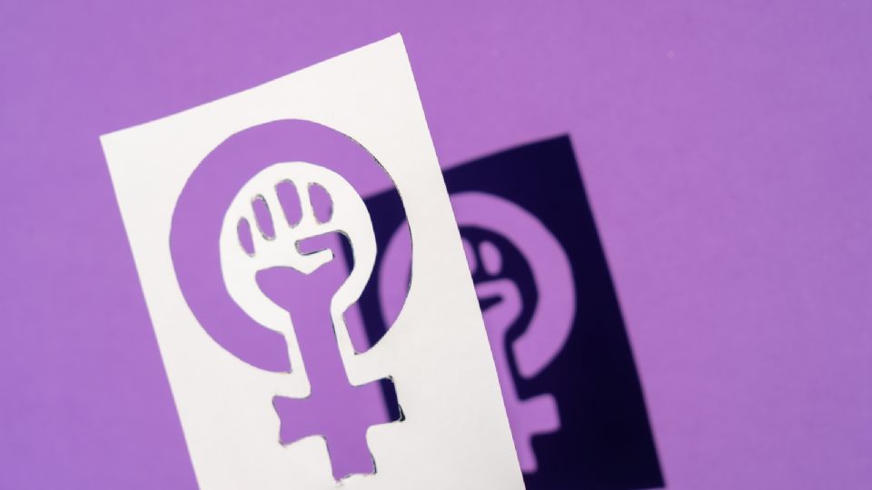 Símbolo de la lucha del feminismo sobre fondo morado / Ilustración