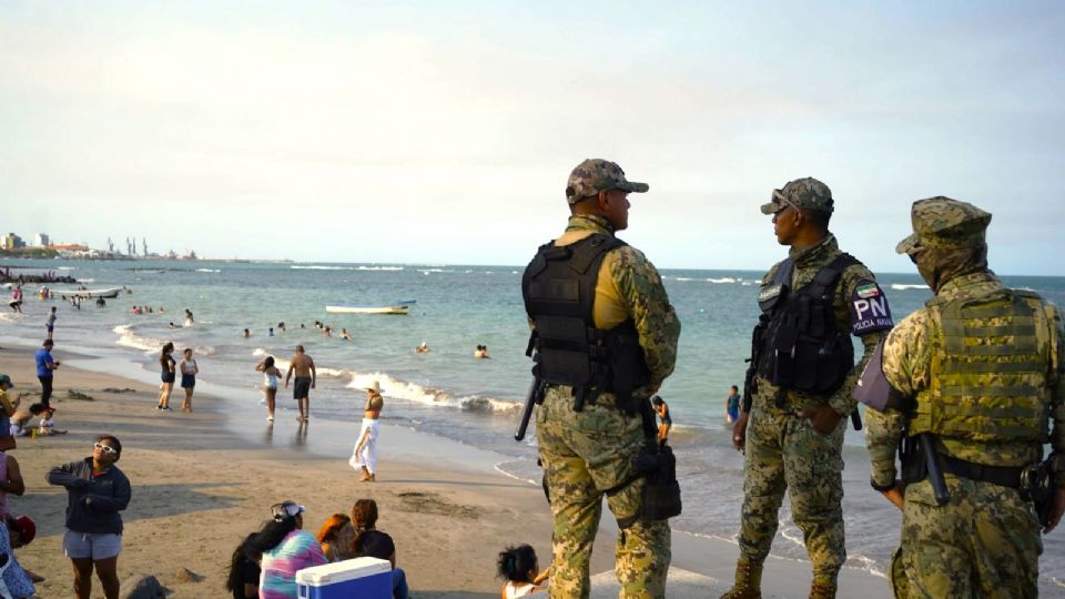 Turistas y la policía naval en una playa de Veracruz.
