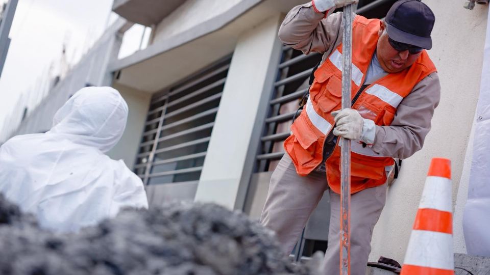 Personal de Agua y Drenaje de Monterrey realiza labores de mantenimiento en la vía pública.