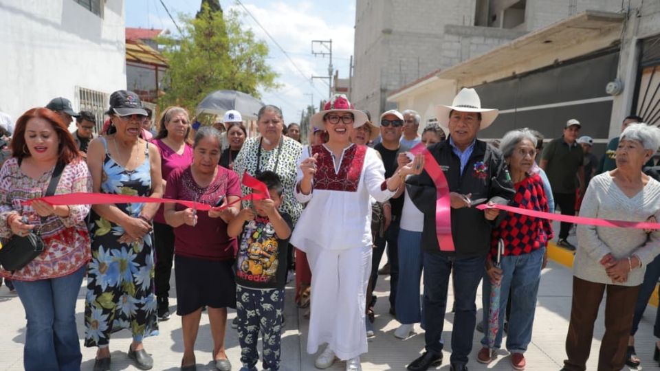 Vecinos y autoridades municipales caminan sobre el nuevo pavimento que incluye palabras conmemorativas en favor de los derechos de las mujeres.
