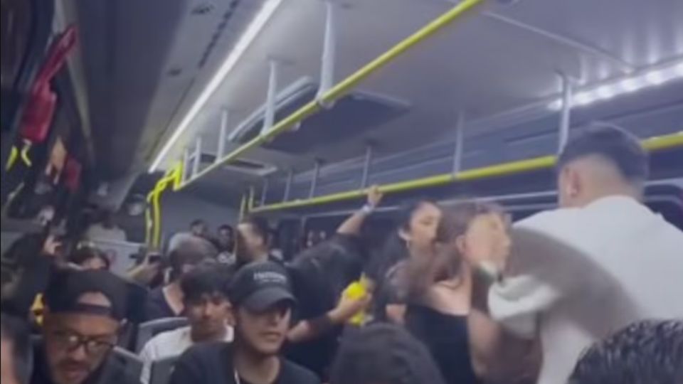 Turistas bailando y celebrando dentro de una unidad de transporte público en la zona hotelera mientras el video se vuelve tendencia mundial.
