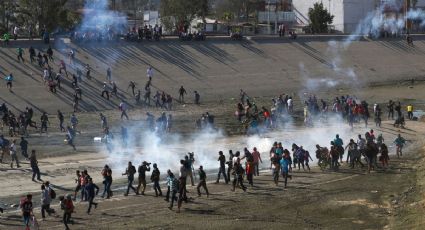 Migrantes intentan cruzar muro fronterizo; lanzan gas lacrimógeno para retenerlos