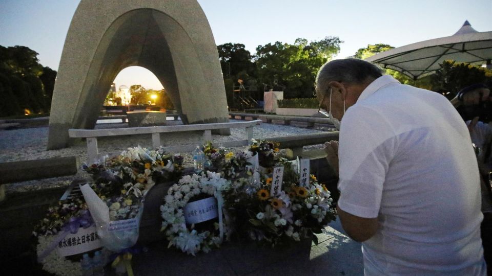 Hombre reza por las víctimas de la bomba atómica de Hiroshima