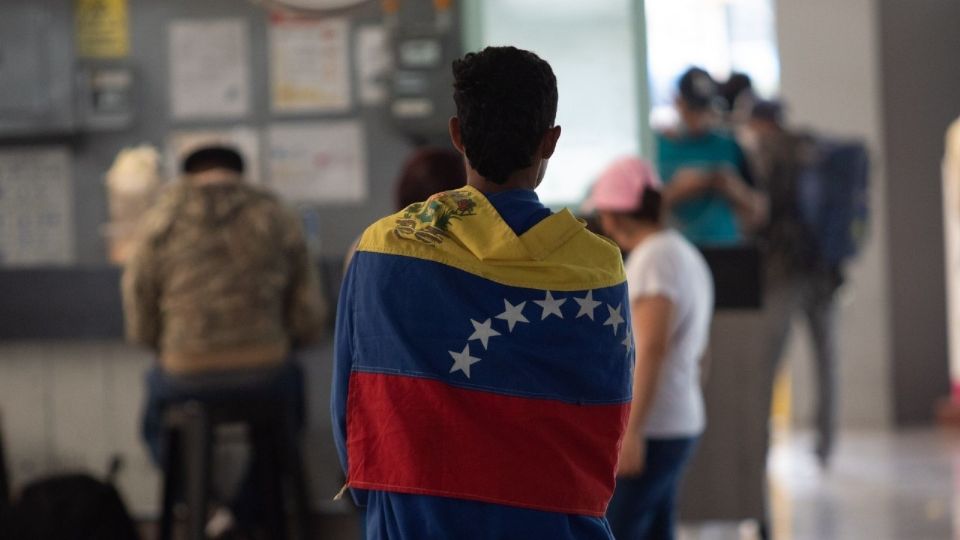 Hombre cubierto con la bandera de Venezuela.