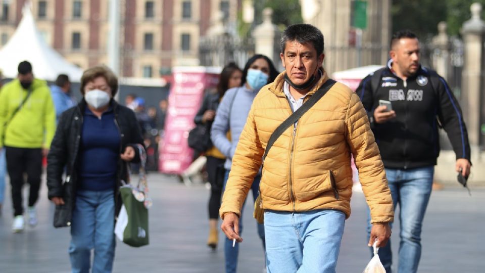 Capitalinos caminan por el Zócalo en medio del frío.