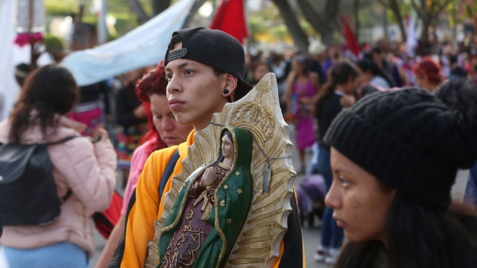 Un joven carga la imagen de una virgen de Guadalupe, esto durante el recorrido de la Virgen