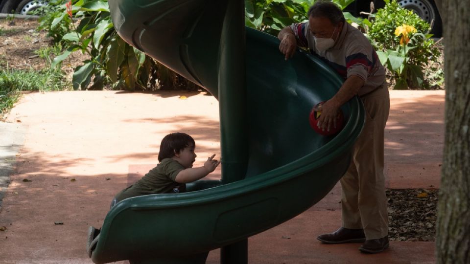 Un niño juega acompañado de su abuelo.