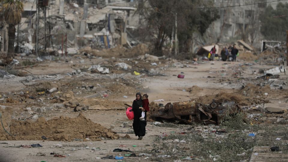 Mujer palestina camina después de cruzar desde el norte de la Franja de Gaza hasta el sur.