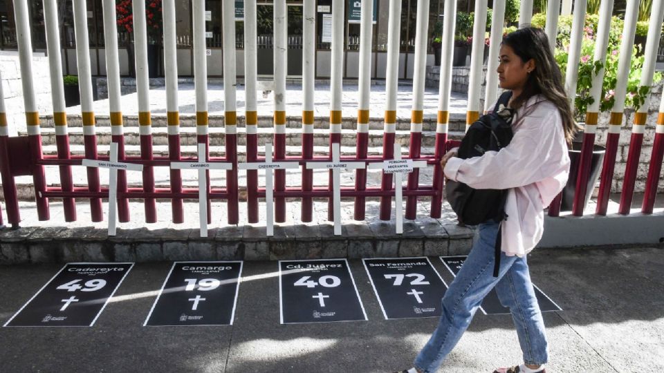 Mujer al exterior de las instalaciones del Instituto Nacional de Migración (INM) en el acto de desagravio y oración en homenaje a los migrantes.