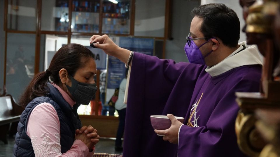 Un padre de la Parroquia Nuestra Señora del Sagrado Corazón, colocando ceniza en la cabeza de los feligreses.