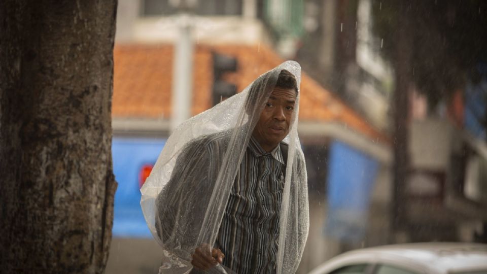 Hombre con bolsa transparente cubriéndose del agua,