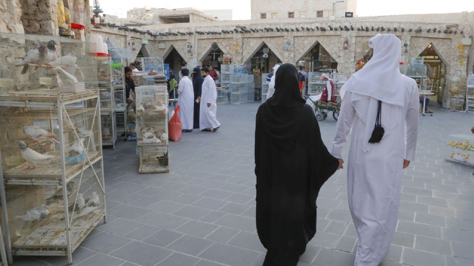 Una pareja pasea por los puestos de pájaros del mercado de Souq Waqif, en Doha.