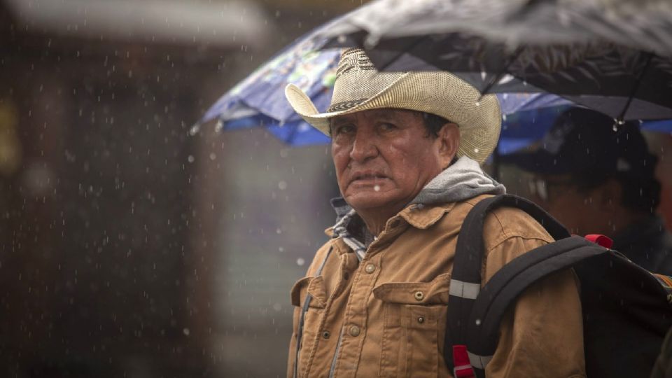 Hombre con sombrero vaquero bajo la lluvia.