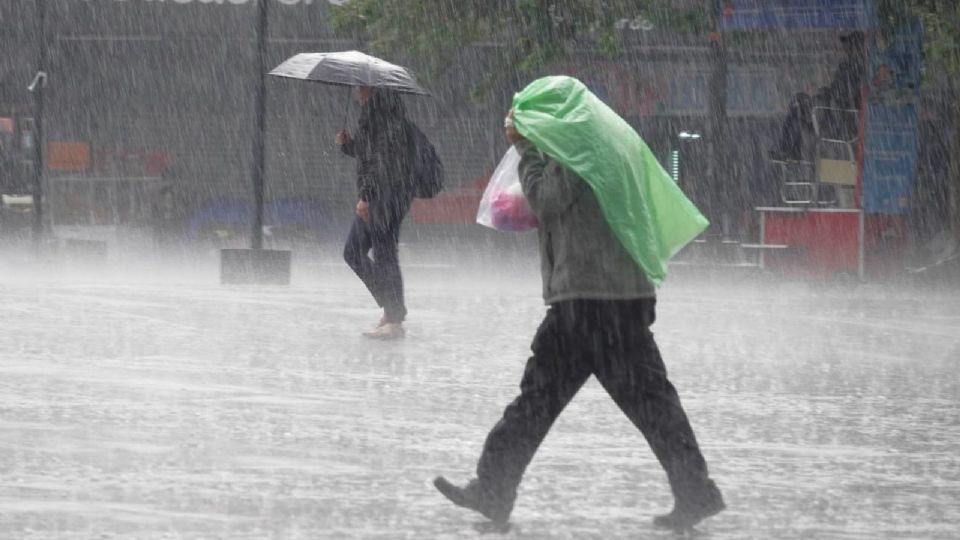 Capitalinos se cubren de la fuertes lluvias en la alcaldía Cuauhtémoc.