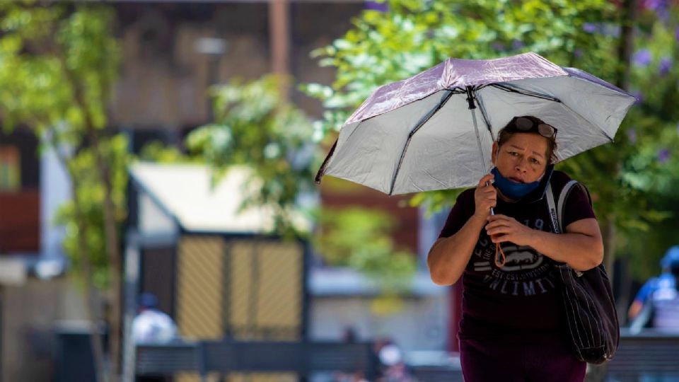 Una mujer se cubre del sol debido a las altas temperaturas en el país.