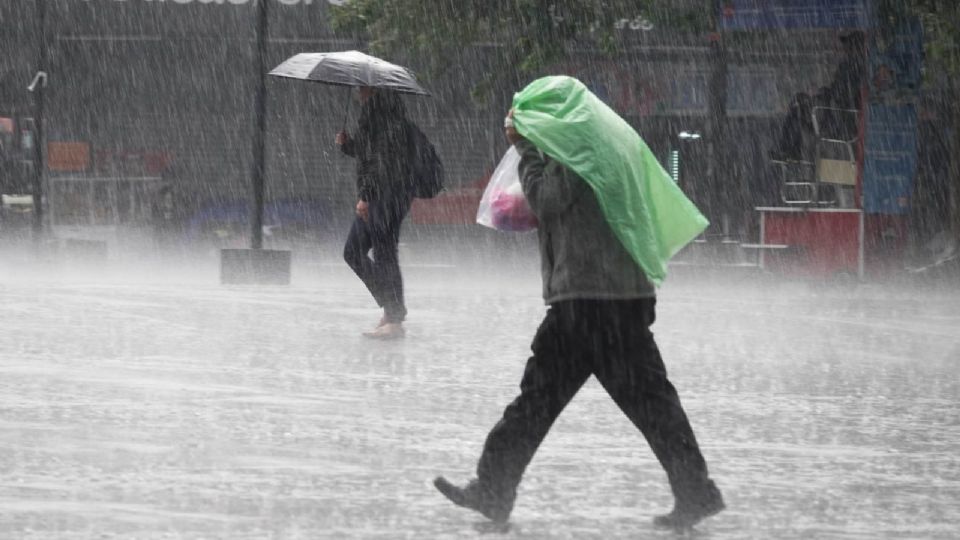Capitalinos se cubren de la fuertes lluvias en la alcaldía Cuauhtémoc.