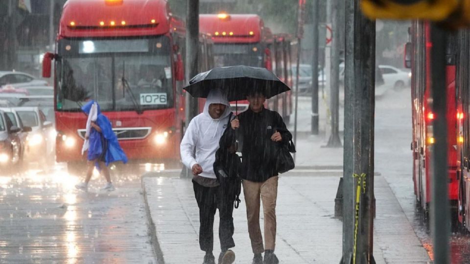 Capitalinos se cubren de las fuertes lluvias.