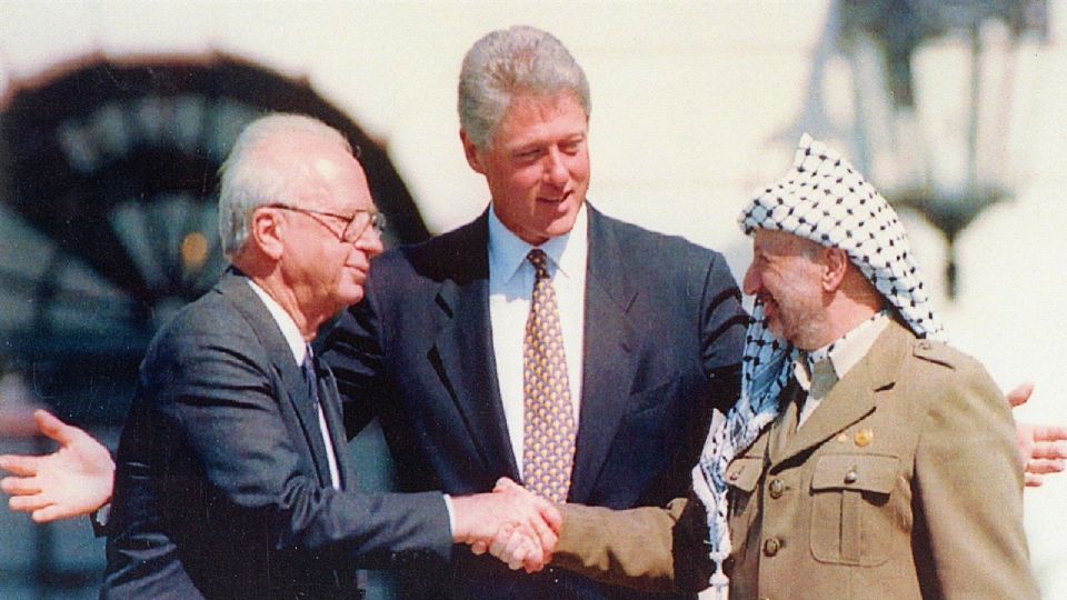 La fotografía data del Tratado de Paz entre Israel y la OLP en Washington D.C., Estados Unidos. Yasser Arafat e Issac Rabin, estrechan sus manos ante la presencia del presidente de Estados Unidos, Bill Clinton.