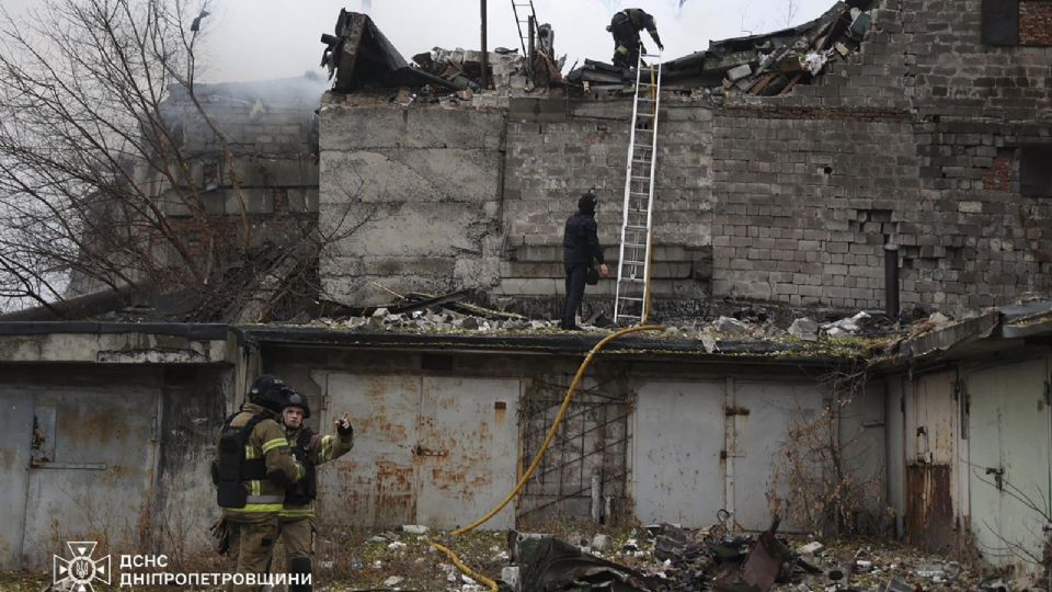 Una fotografía proporcionada por el Servicio Estatal de Emergencia muestra a los rescatistas ucranianos trabajando en el lugar del ataque con cohete en Dnipro, Ucrania.