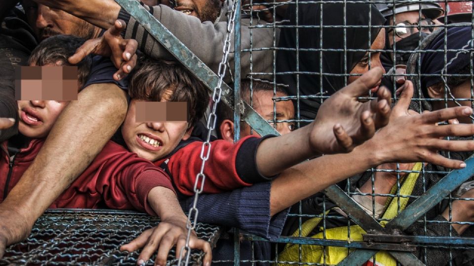 Palestinos hacen cola para recibir comidas gratuitas durante el mes sagrado de ayuno musulmán del Ramadán, en el campo de refugiados de Jabalia, en la Franja de Gaza.