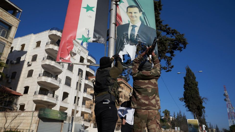 Combatientes de la oposición siria rompen un retrato del presidente sirio Bashar al-Assad en el centro de Alepo, Siria, el 30 de noviembre de 2024.