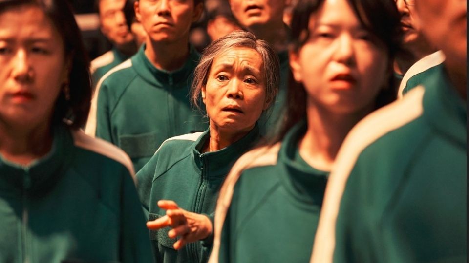 Los jugadores, con sus chándales verdes numerados, esperan en fila la siguiente prueba en 'El juego del calamar'.