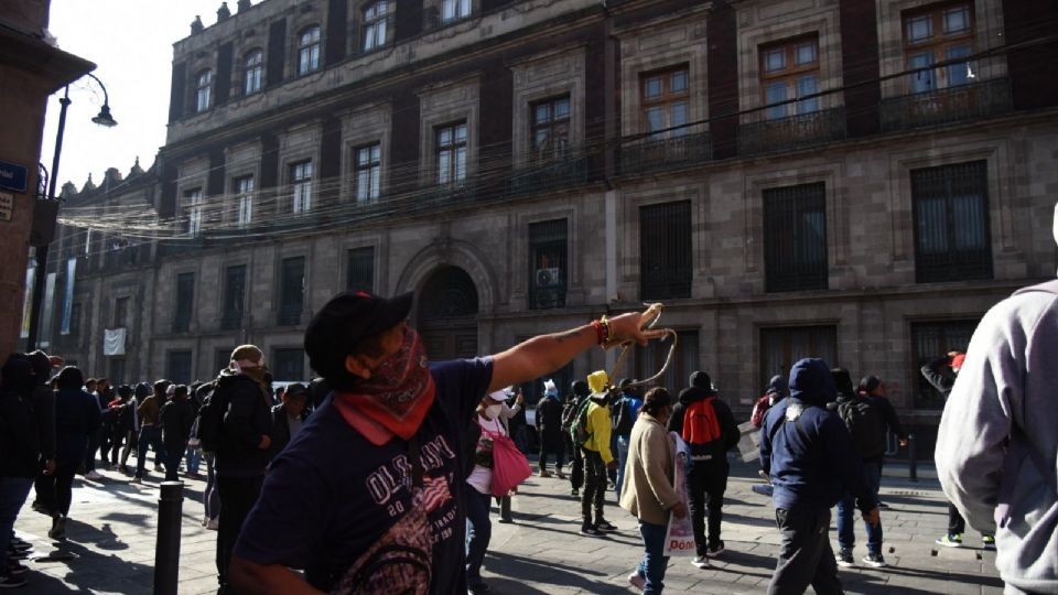 Madres y padres de estudiantes de Ayotzinapa irrumpieron la puerta de Palacio Nacional con violencia