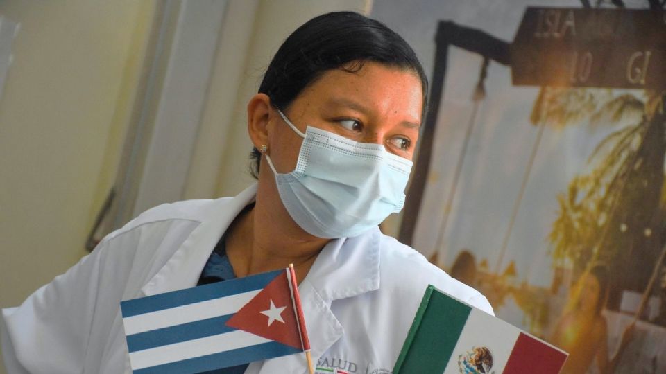 Un médico sostiene una bandera de México y otra de su país, Cuba.