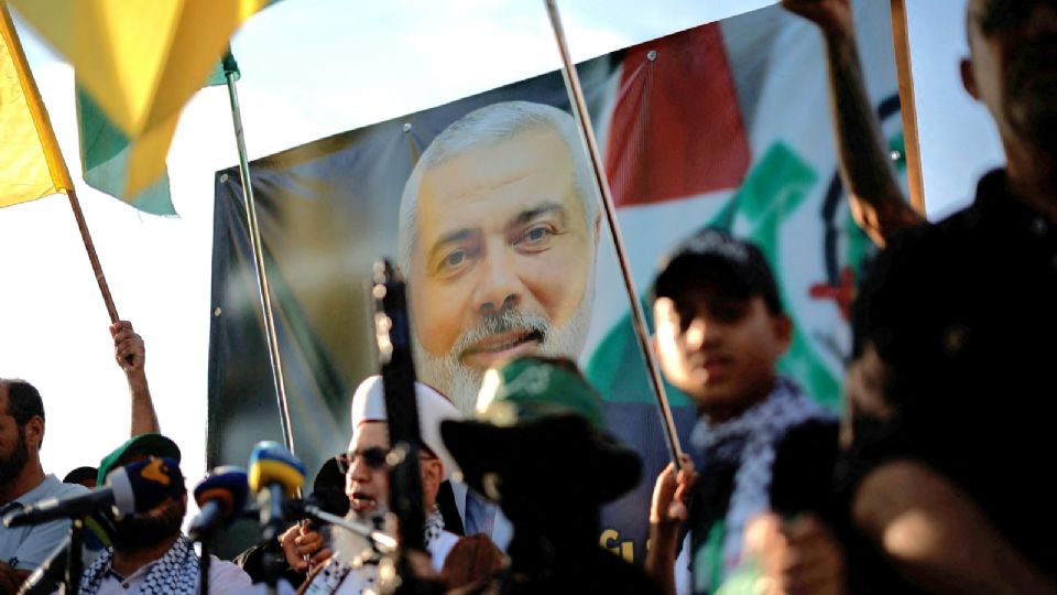 Manifestantes sostienen banderas y armas junto a una imagen del fallecido líder de Hamás Ismail Haniyeh, durante una protesta para condenar su asesinato en Irán, en Sidón, Líbano, 31 de julio de 2024.