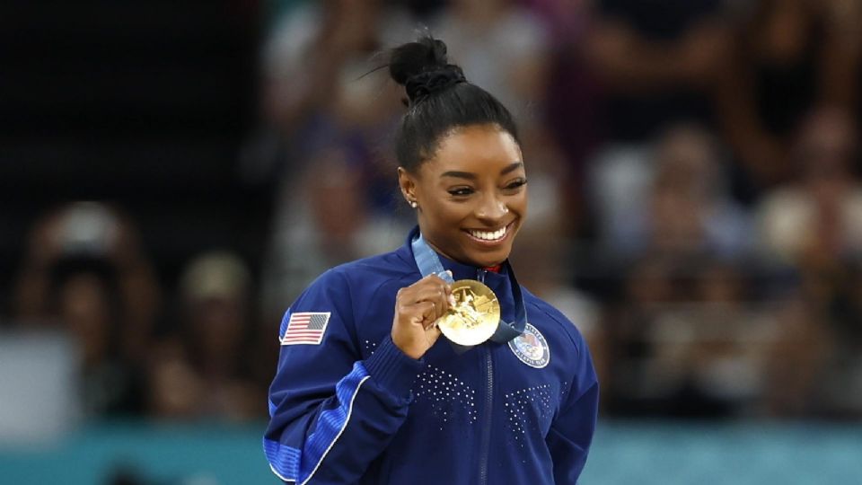 La primera medallista de oro, Simone Biles, de Estados Unidos, posa en el podio de la final femenina de las competencias de gimnasia artística en los Juegos Olímpicos de París 2024.