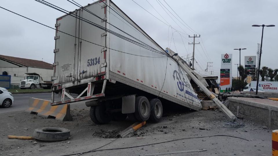 El tráiler impactó varios postes y muros de contención, dejando cables caídos y a un conductor lesionado.