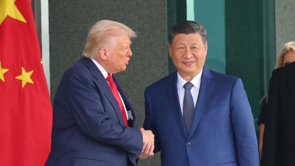 Donald Trump (izq.) y el presidente chino Xi Jinping (centro) se dan la mano tras su reunión en el salón de recepciones Naraemaru.